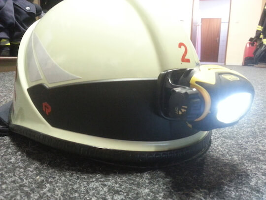Helmlampe am Feuerwehrhelm montiert, leuchtet